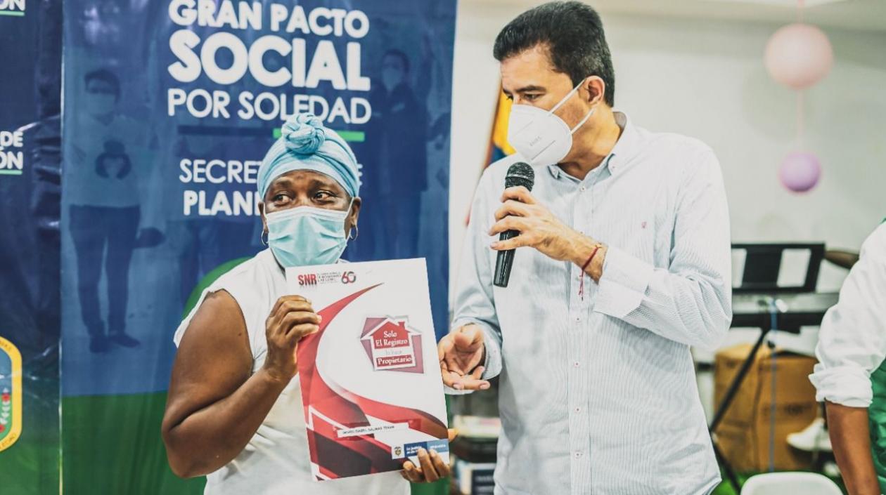 El alcalde Rodolfo Ucrós entregando un título de propiedad a una de las familias beneficiadas. 