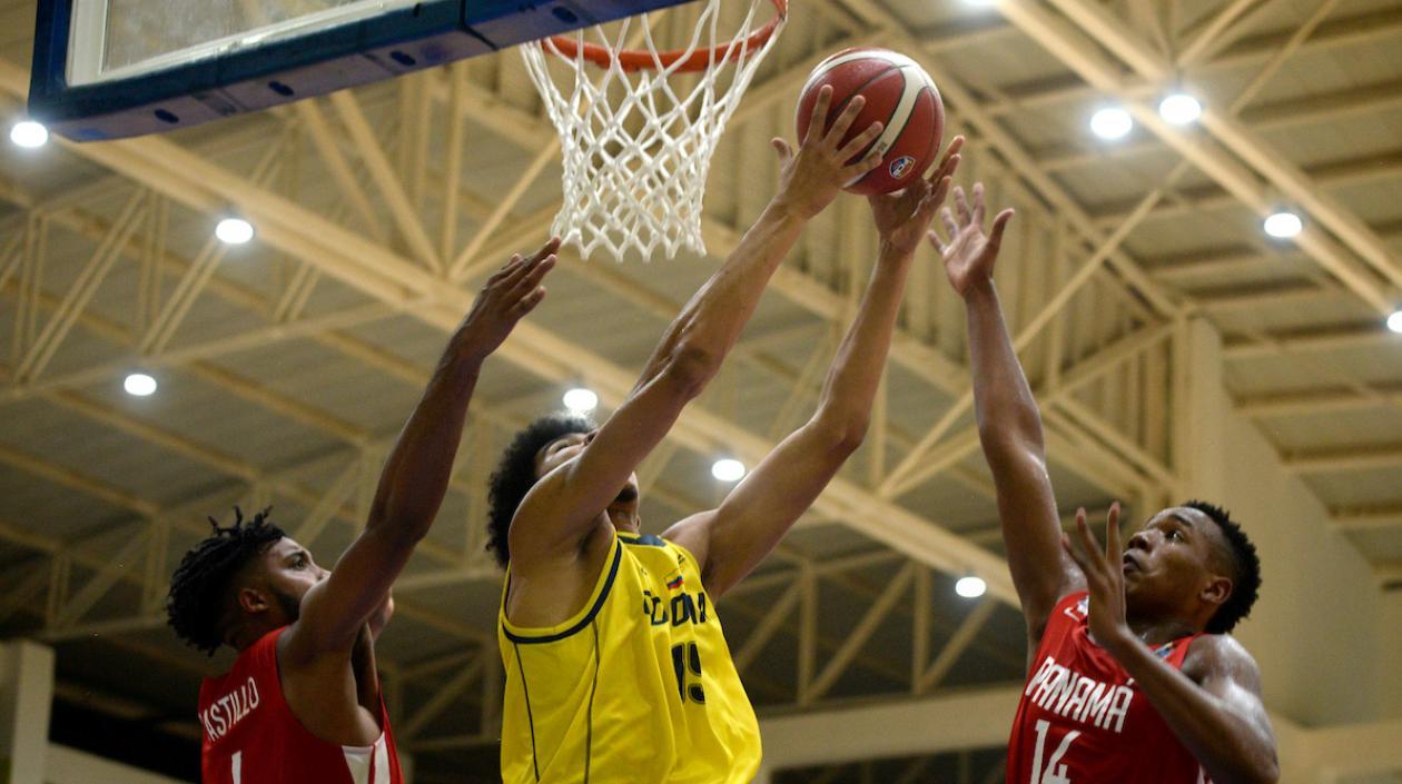 Edwin Niebles intenta encestar ante la marca panameña. 