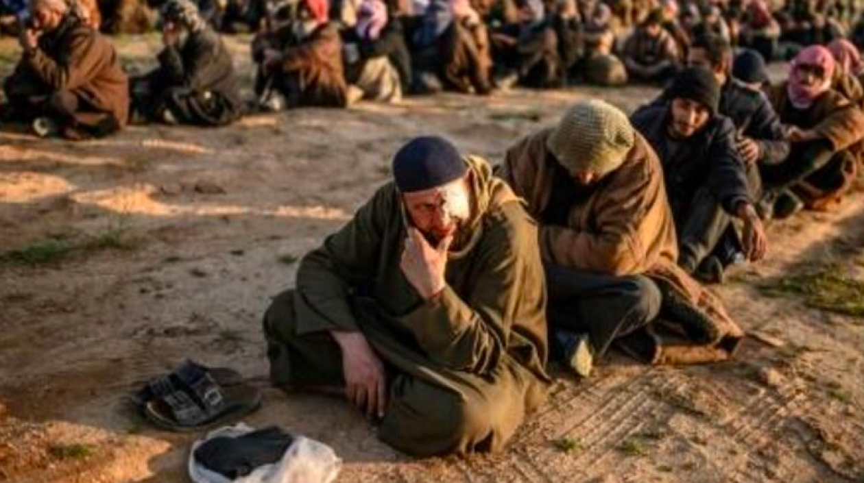 Foto captada en 2019 cuando hombres sospechosos de ser combatientes del Estado Islámico (EI) esperan a ser registrados por miembros de las Fuerzas Democráticas Sirias 