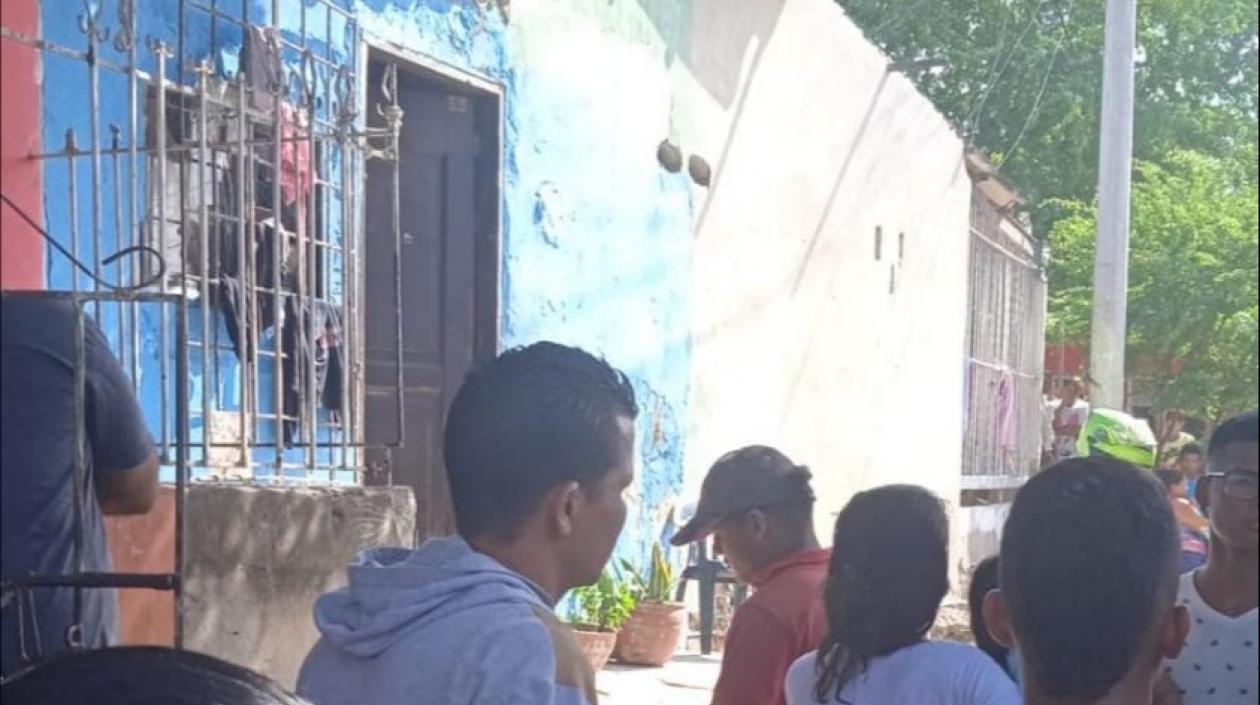 Curiosos se reúnen en el frente de la vivienda en la que fueron asesinadas dos mujeres.