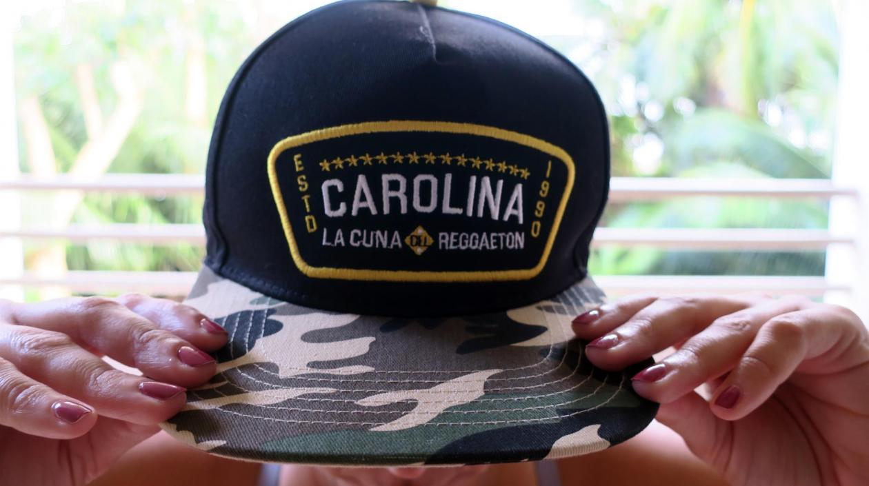 Una mujer muestra hoy una gorra con el nombre de "Carolina", municipio considerado como la cuna del reguetón, en San Juan (Puerto Rico).