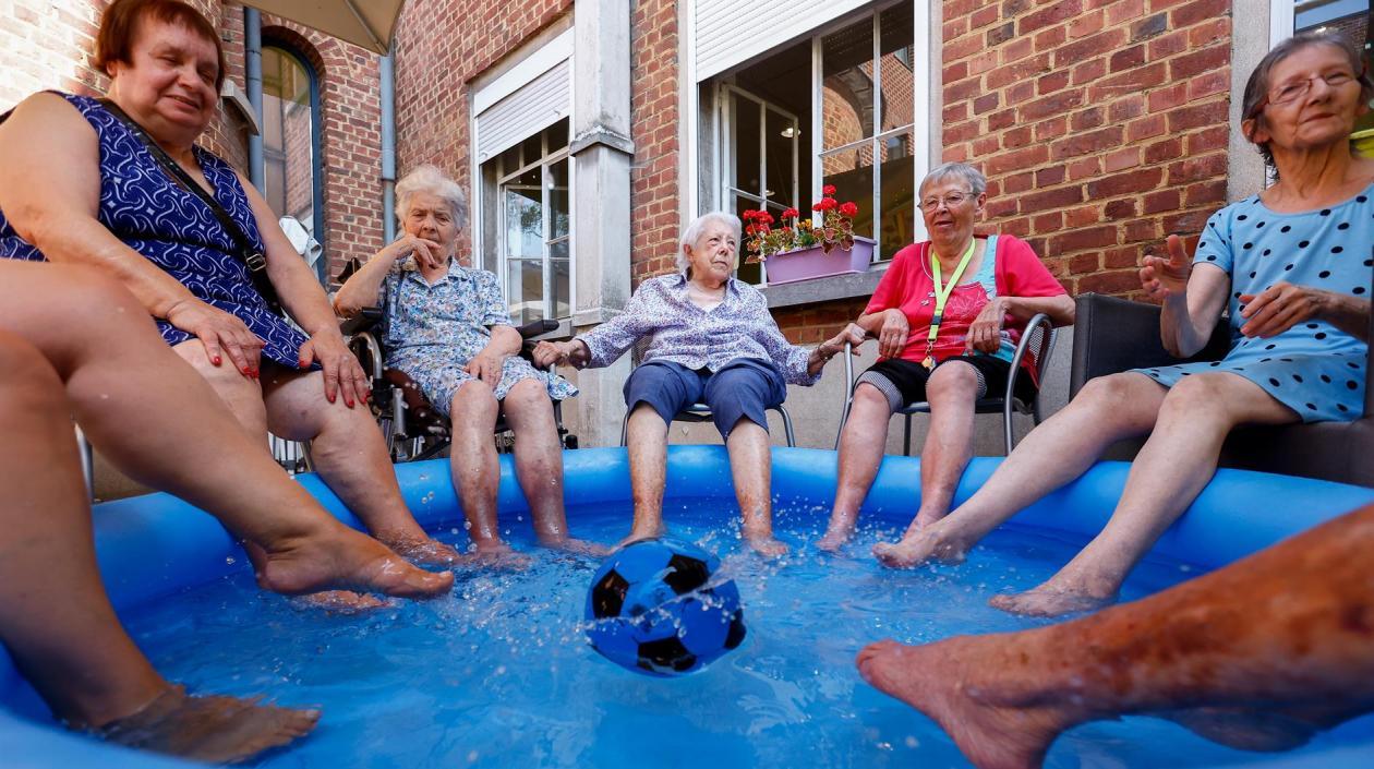 Mujeres se refrescan con los pies metidos en una piscina de plástico en una residencia de ancianos en Chatelet, Bélgica, donde se registran temperaturas de hasta 40 grados. 