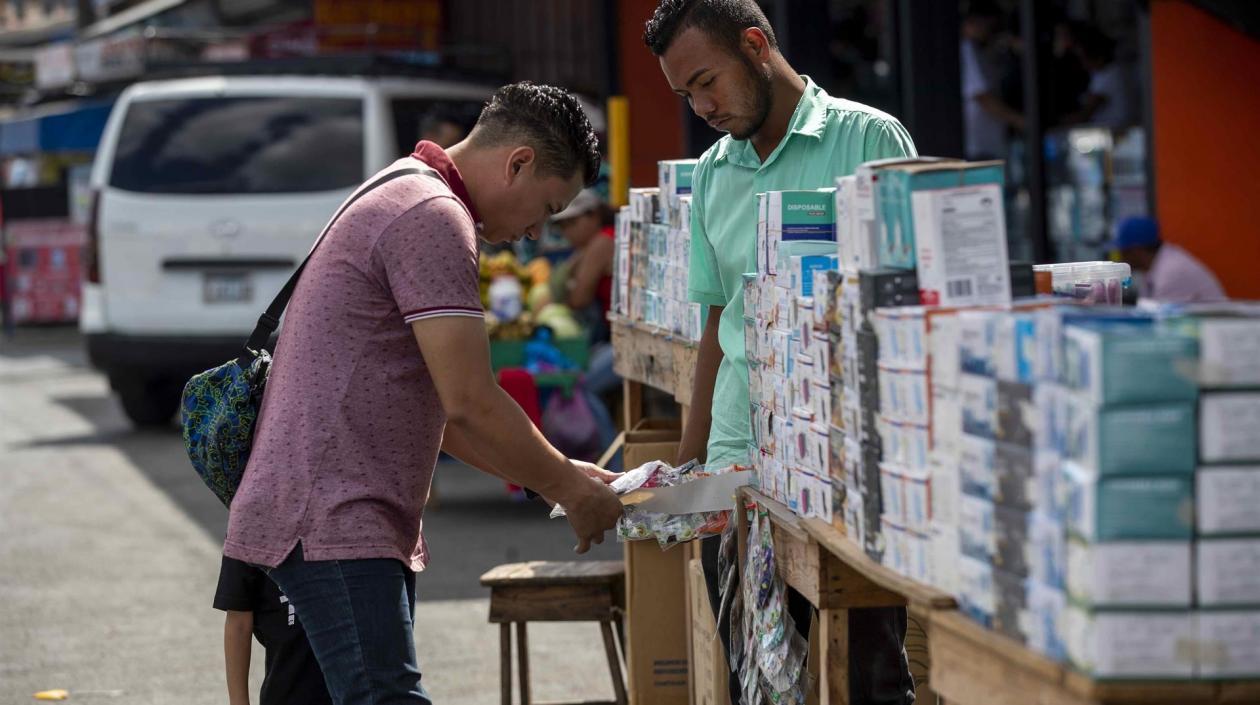 Foto de archivo de una persona comprando tapabocas en el centro de Managua.