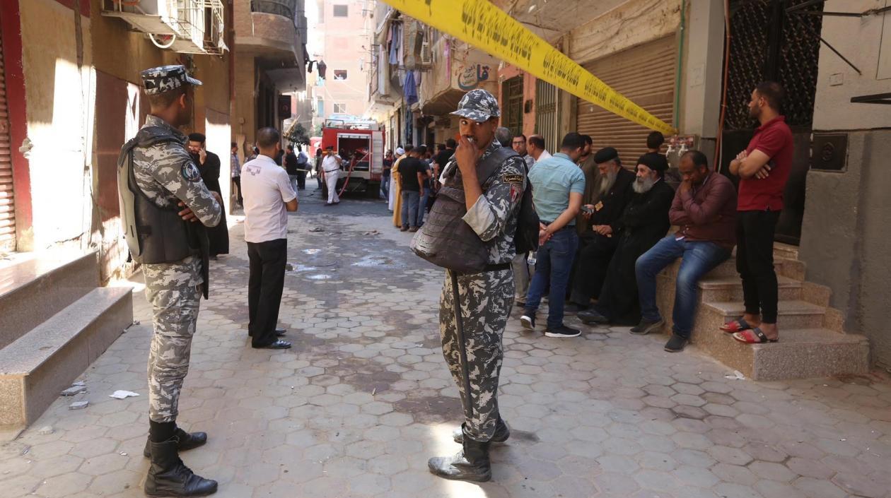  Personas y militares aguardan en las afueras de la iglesia que se incendió en El Cairo.