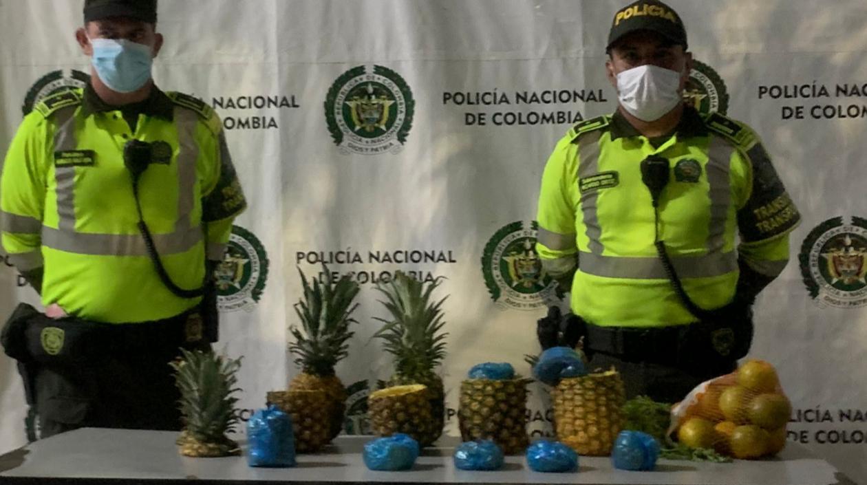 Dos uniformados frente a parte de las piñas incautadas en cuyo interior había marihuana.