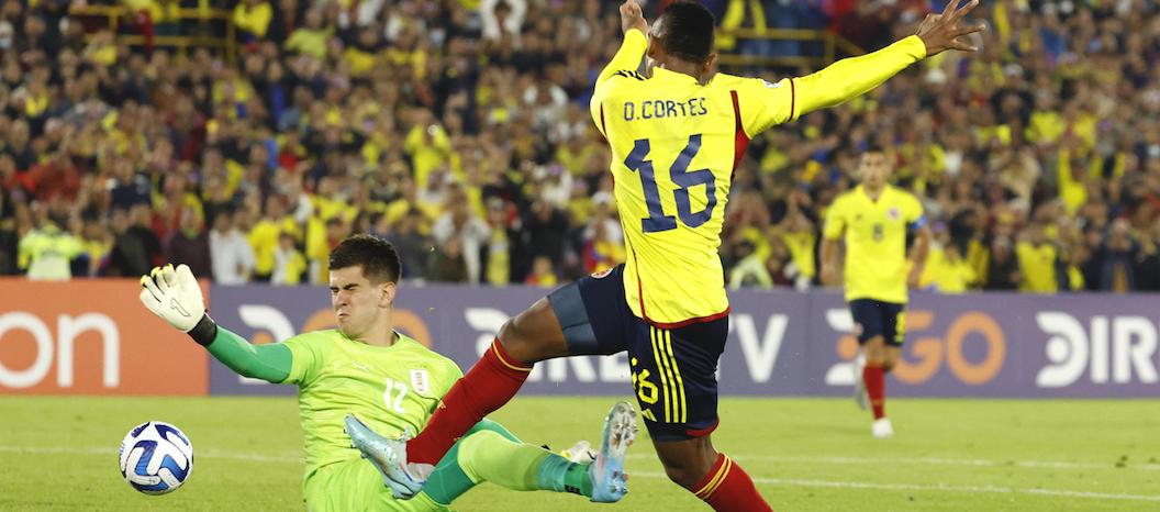 Óscar Cortés rematando frente al arquero uruguayo Lucas Rodríguez.