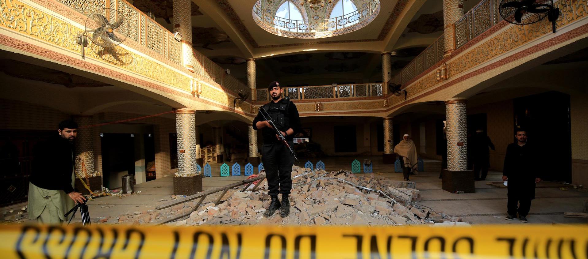 Un policía monta guardia en el interior de la mezquita en Peshawar, tras un ataque suicida.