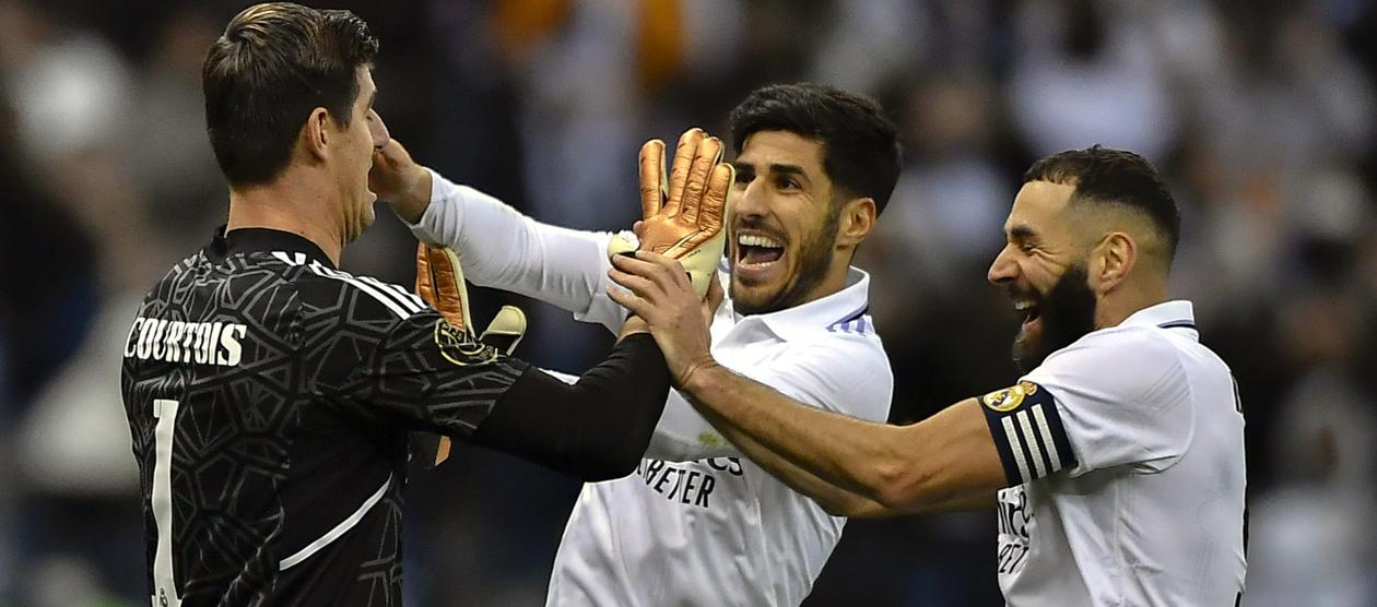 Thibaut Courtois es felicitado por Karim Benzema y Marco Asensio.