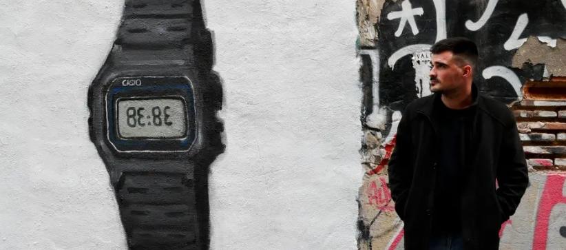 J. Warx posa ante su grafiti inspirado en el más reciente éxito de la cantante colombiana Shakira.