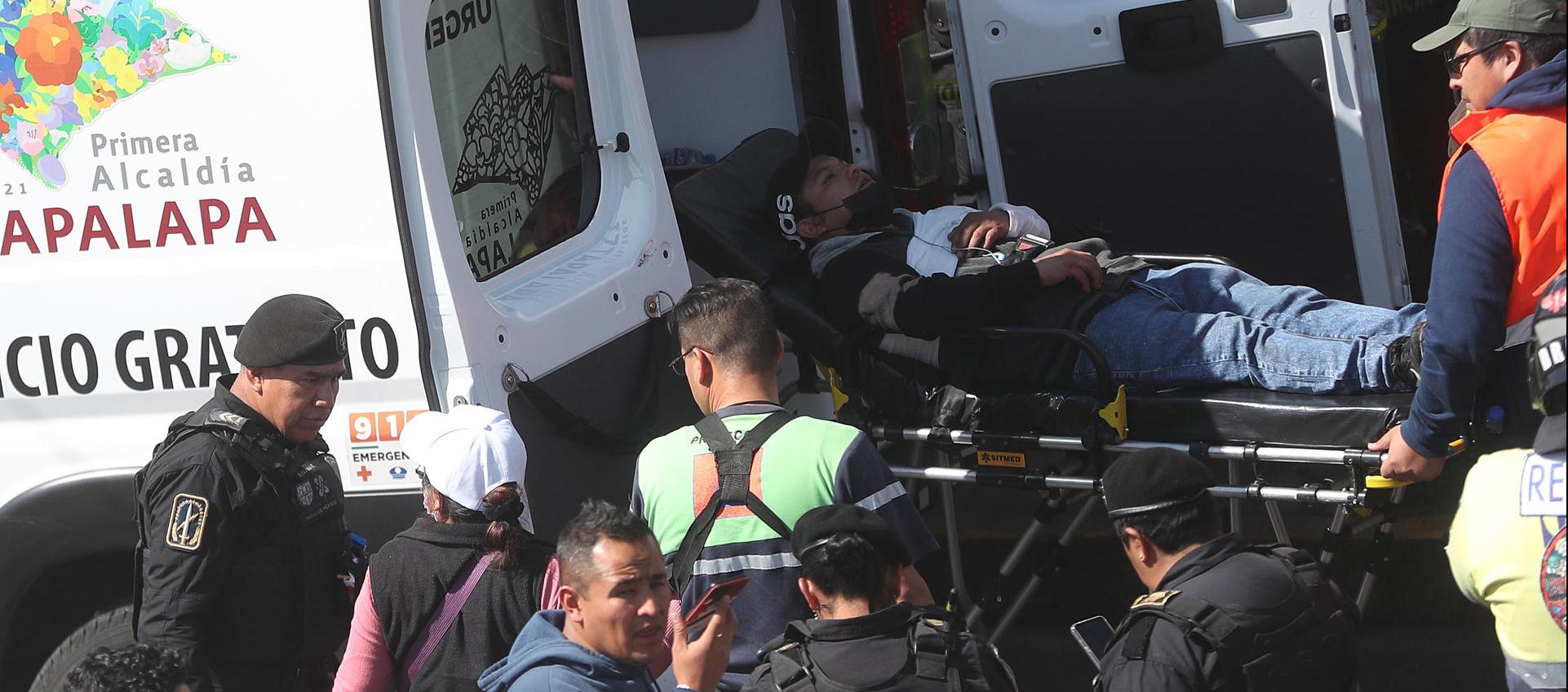 Miembros de los servicios de emergencia trasladan a un herido.