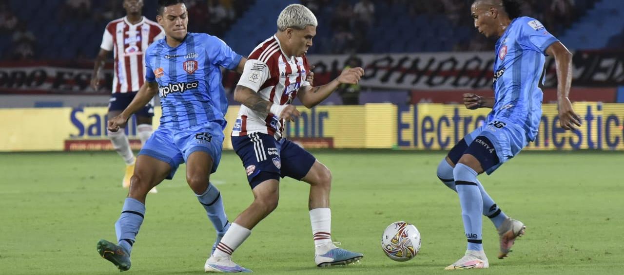 Juan Fernando Quintero intentando eludir a dos visitantes.