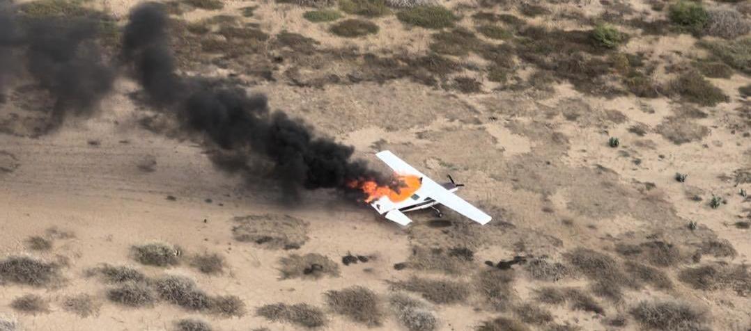 La avioneta siendo consumida por el fuego.