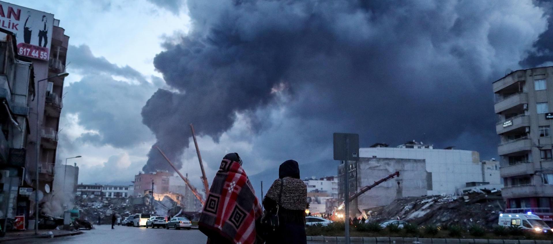 Dos personas observan los destrozos ocasionados por los terremotos en Hatay, Turquía