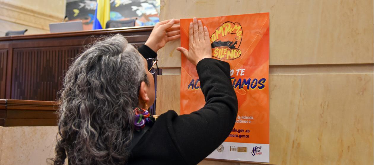La senadora María José Pizarro pega un cartel en contra del abuso sexual en la sede del Congreso.
