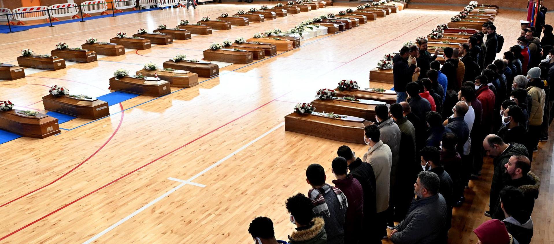 Varios ataúdes con los restos mortales de las 70 personas, entre ellas 20 menores, que murieron en las costas de Calabria, Italia, reposan en el palacio de deportes de Crotone.