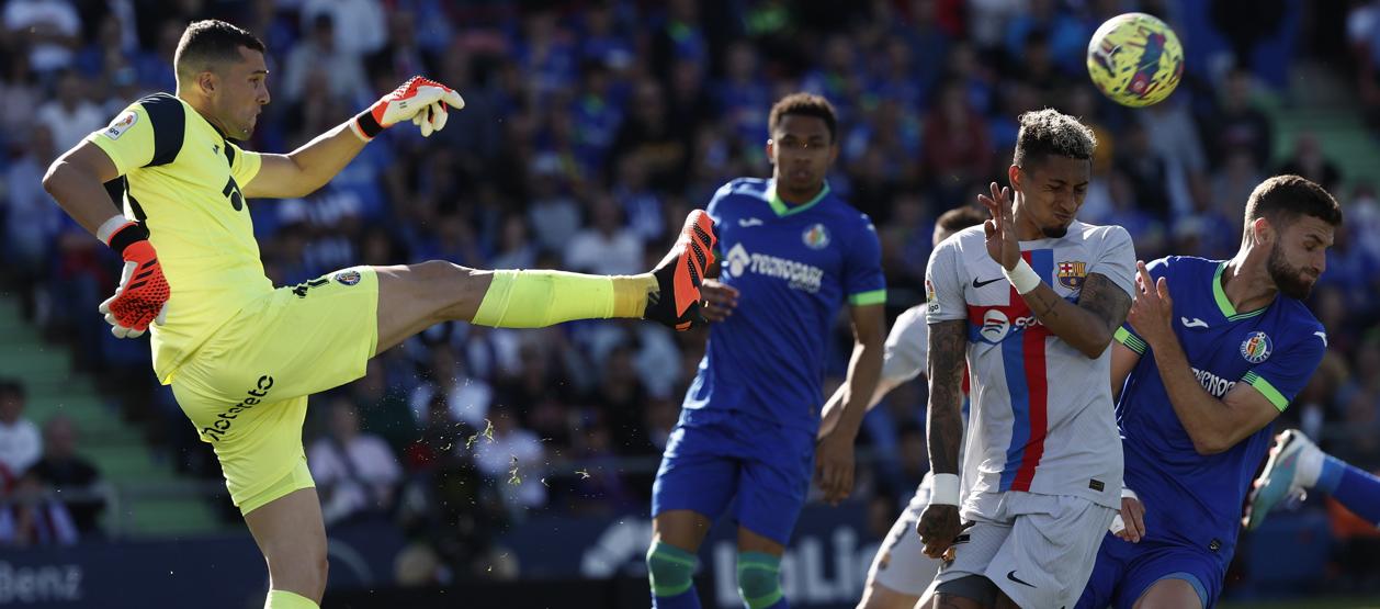 David Soria, portero del Getafe, despeja la pelota ante la llegada de Raphinha.