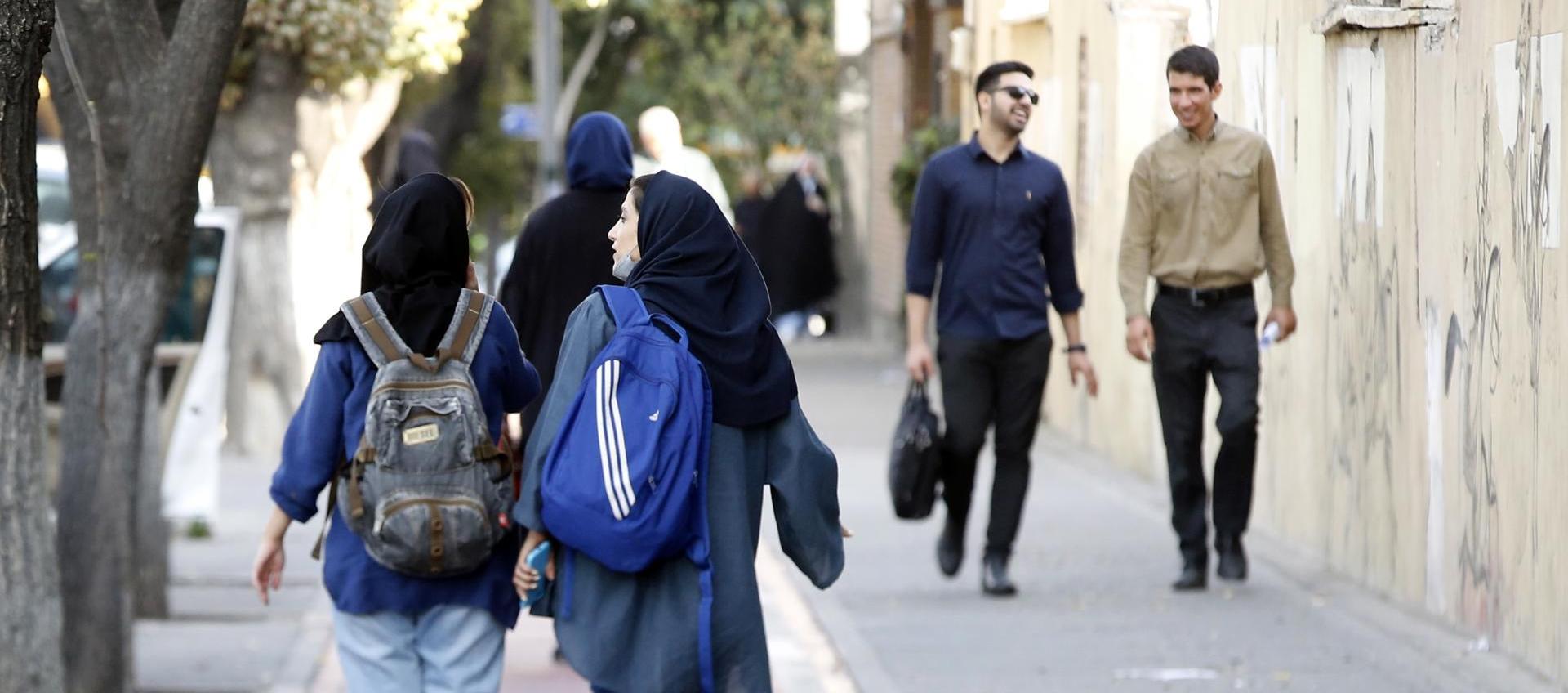 Jóvenes iraníes con pañuelo en la cabeza en una calle de Teherán en octubre de 2022