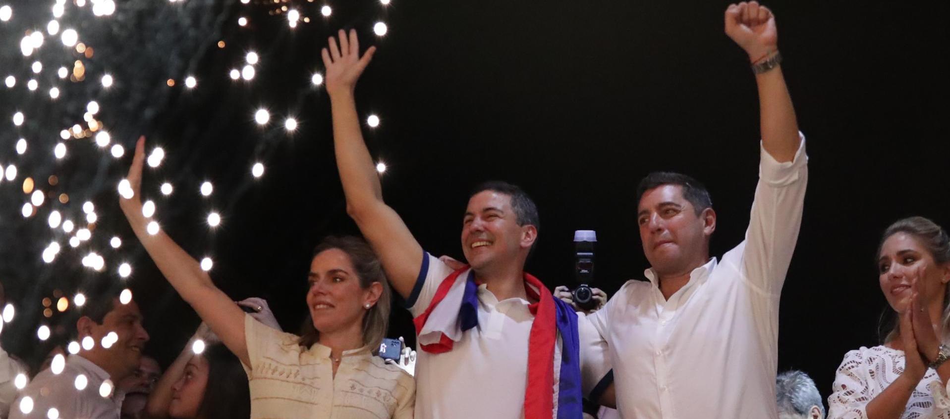 El presidente electo de Paraguay, Santiago Peña, celebra junto a su esposa Leticia Ocampos y el vicepresidente electo (der.), Pedro Alliana, tras su victoria este domingo.