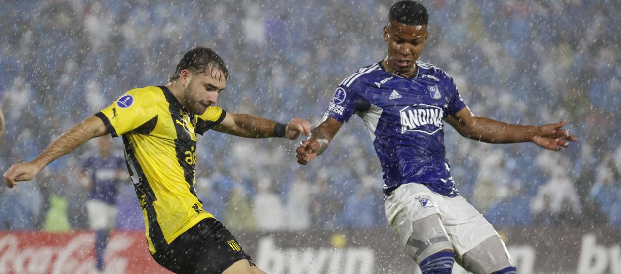 Beckham Castro, de Millonarios, intenta impedir el avance de Pedro Milans. 