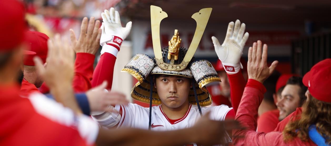 Shohei Ohtani es felicitado por sus compañeros en el dugout.