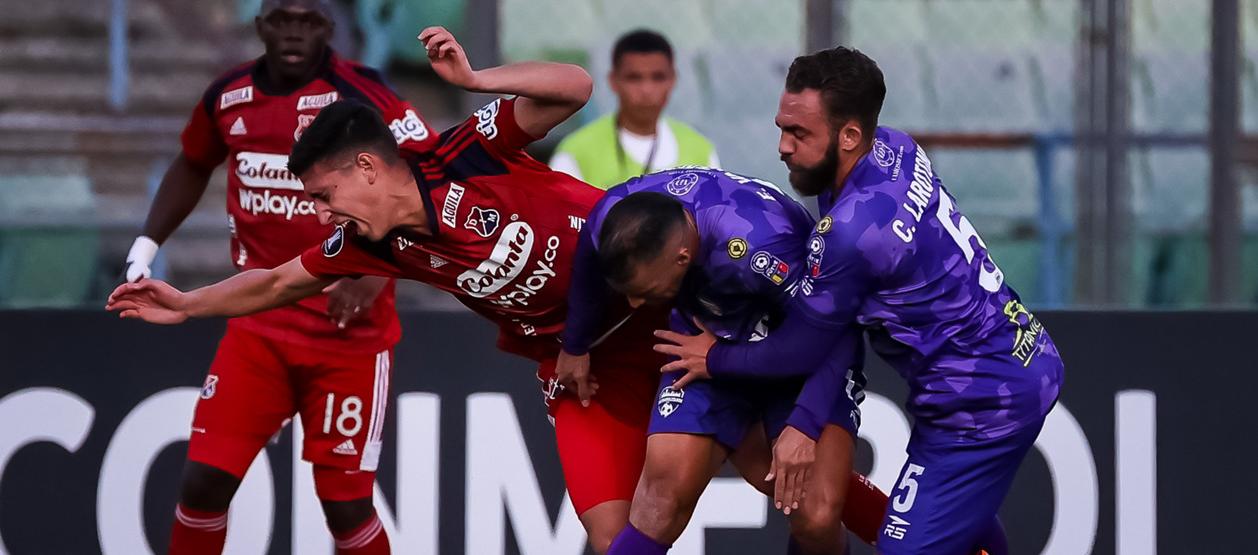 Miguel Monsalve intenta escapar de la marca de dos jugadores rivales 