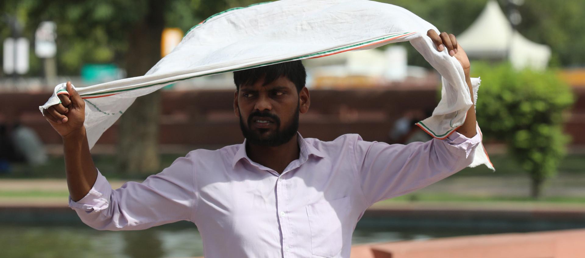 Un ciudadano de India se protege del intenso sol.