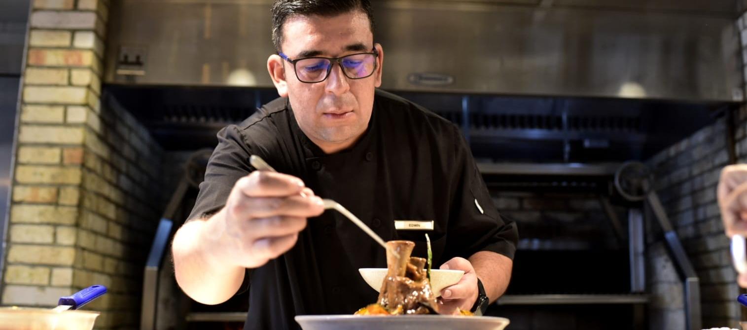 Edwin Marín Palma en pleno emplatado del osobuco de ternera con arroz caldoso de guandú y champiñones