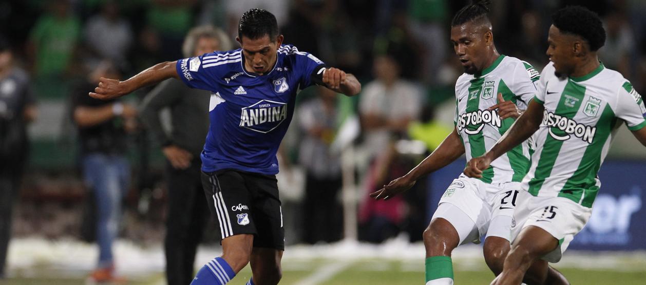 David Macalister Silva encara dos rivales de Nacional durante el partido en Medellín. 