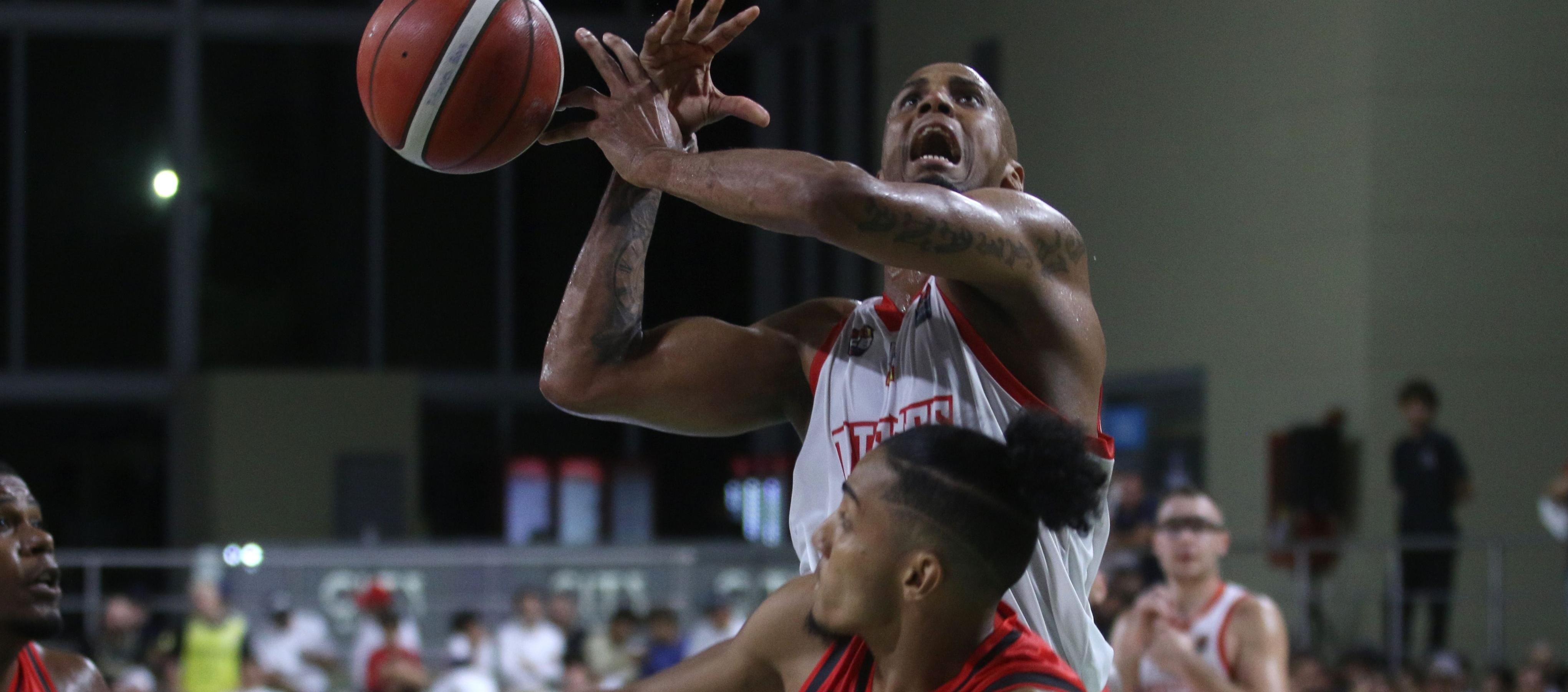 El panameño Ernesto Oglivie intenta encestar ante la presión de un rival.