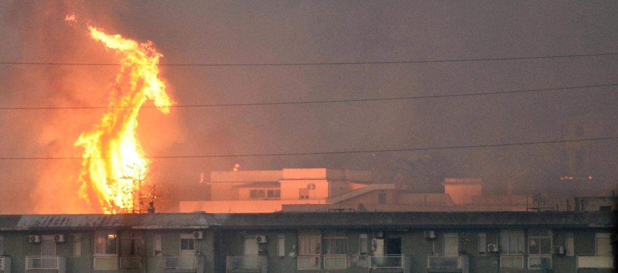 Columna de fuego se eleva tras un bloque de viviendas en el área de Monte Grifone, en Italia.
