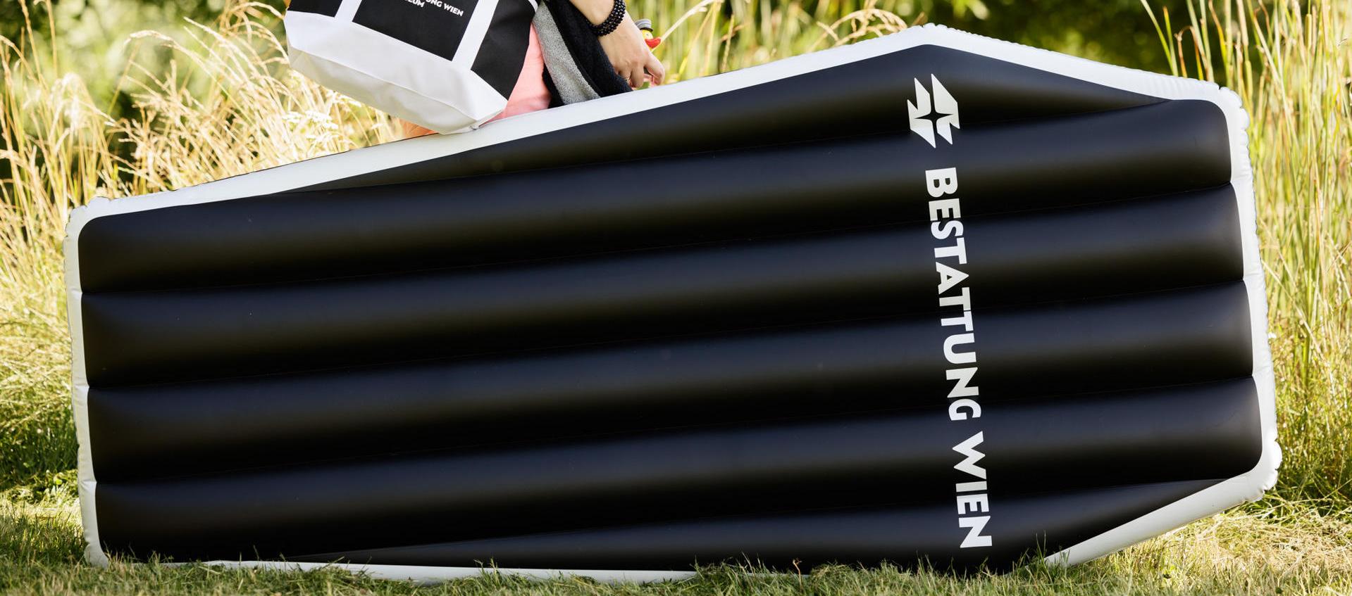 Set de verano: colchoneta inflable, en forma de ataúd, toalla y bolsa de tela del museo funerario del cementerio de Viena.