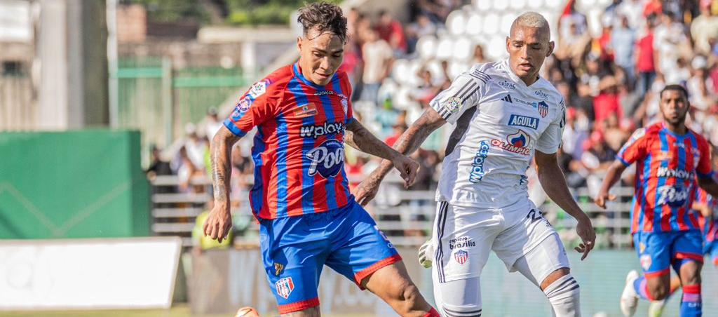 Ricardo Márquez intenta avanzar seguido de cerca por Jermein Peña. 