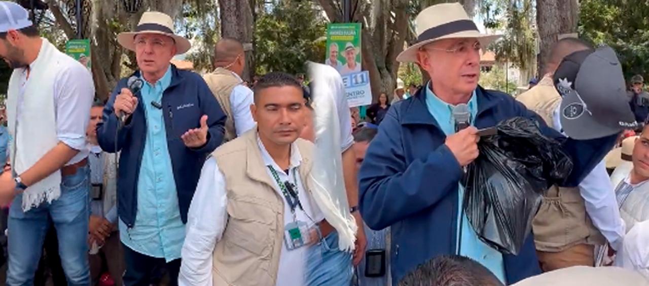 Álvaro Uribe Vélez sacando las gorras compradas.