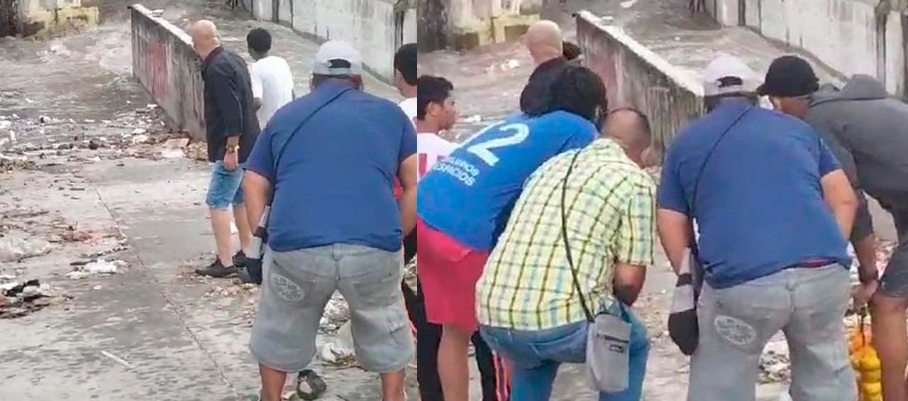 Vecinos viendo como los niños son arrastrados.