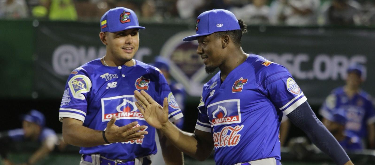 Jesús Marriaga, el pelotero más destacado de Caimanes en el juego, recibe el saludo del mánager Carlos Vidal.