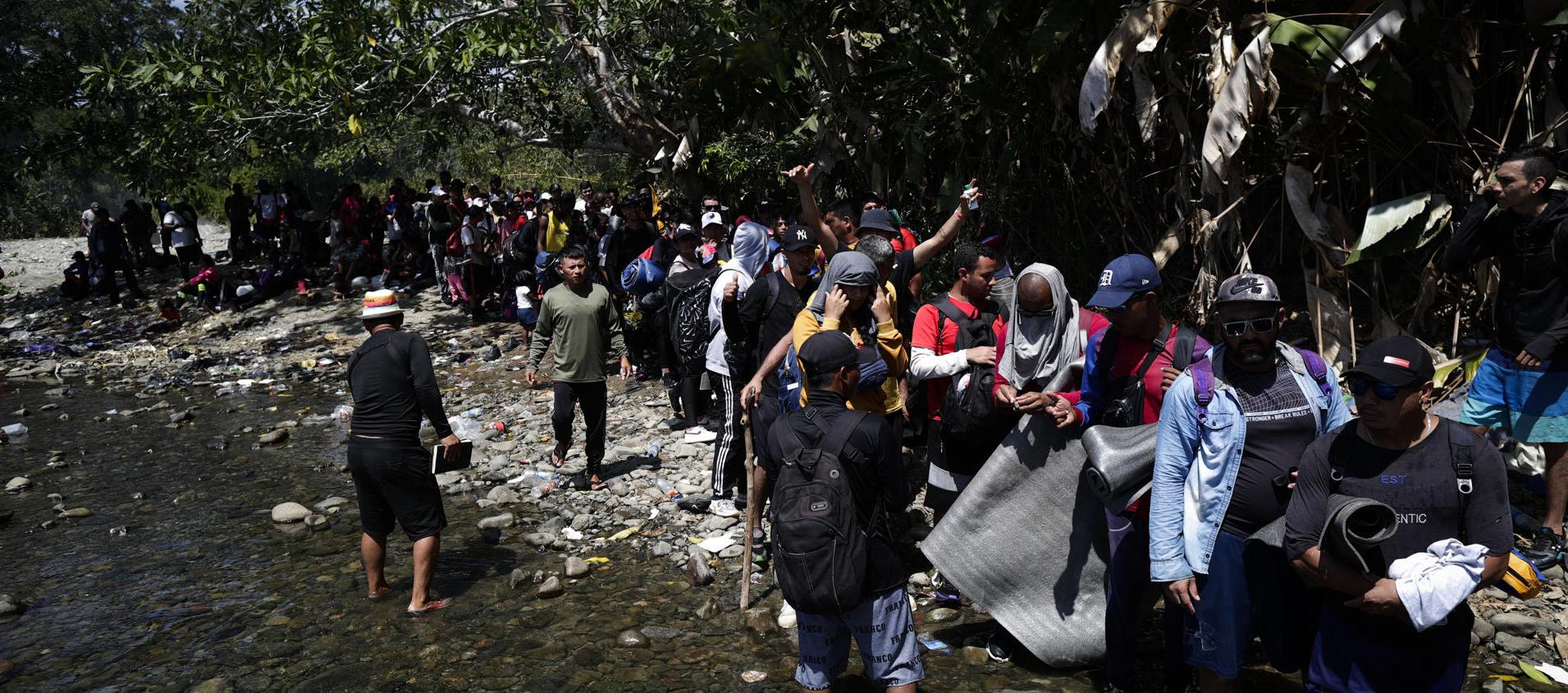 Migrantes esperan para ser trasladados en canoa desde la Quebrada León hasta Bajo Chiquito, en Darién (Panamá)
