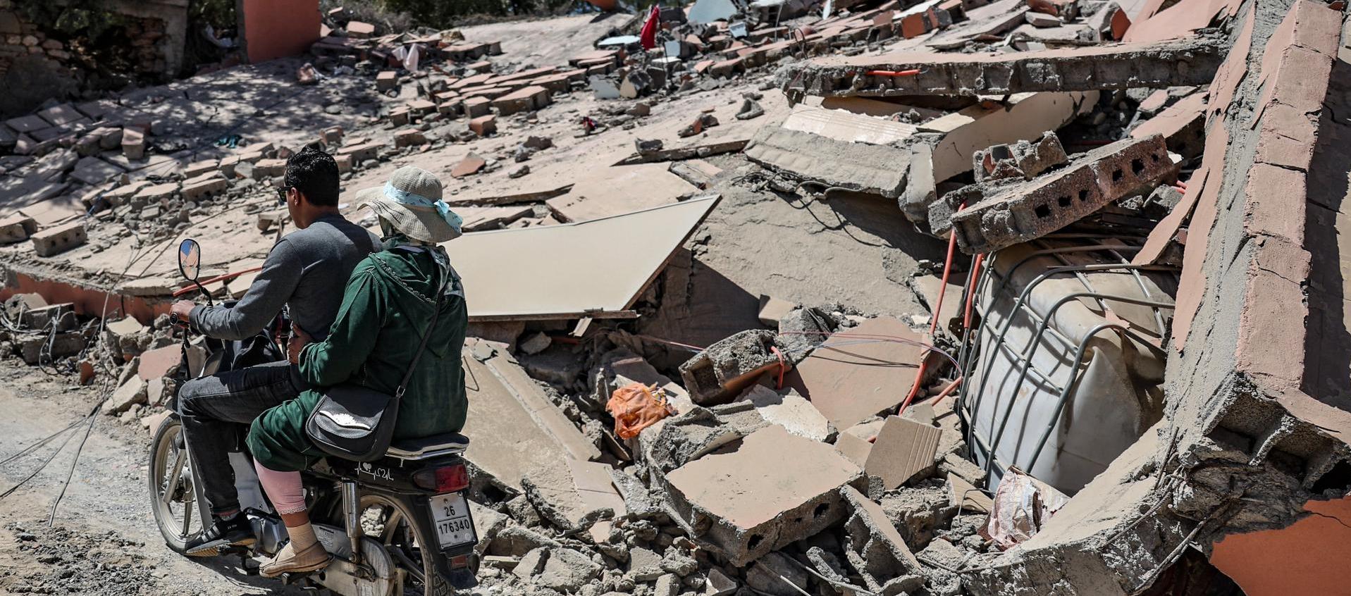 Dos motorizados pasan frente a los destrozos que dejó el terremoto en Marruecos