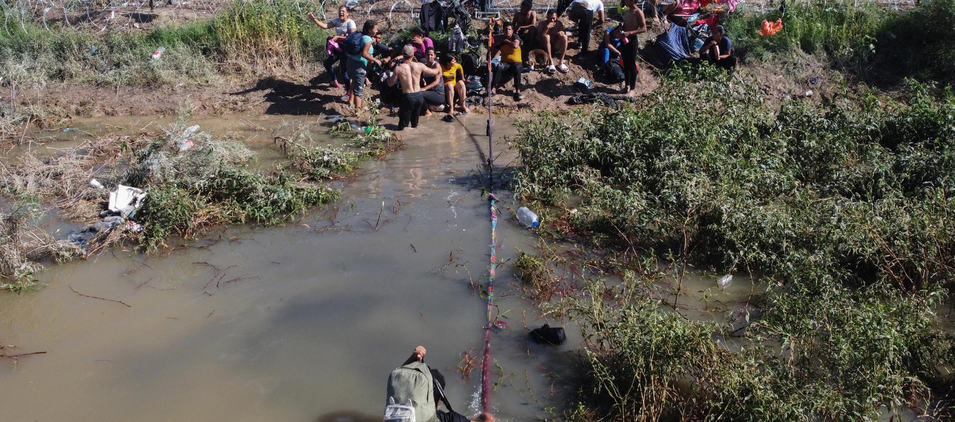 Migrantes esperan para cruzar el río Bravo hacía la frontera con Estados Unidos, este miércoles en Ciudad Juárez