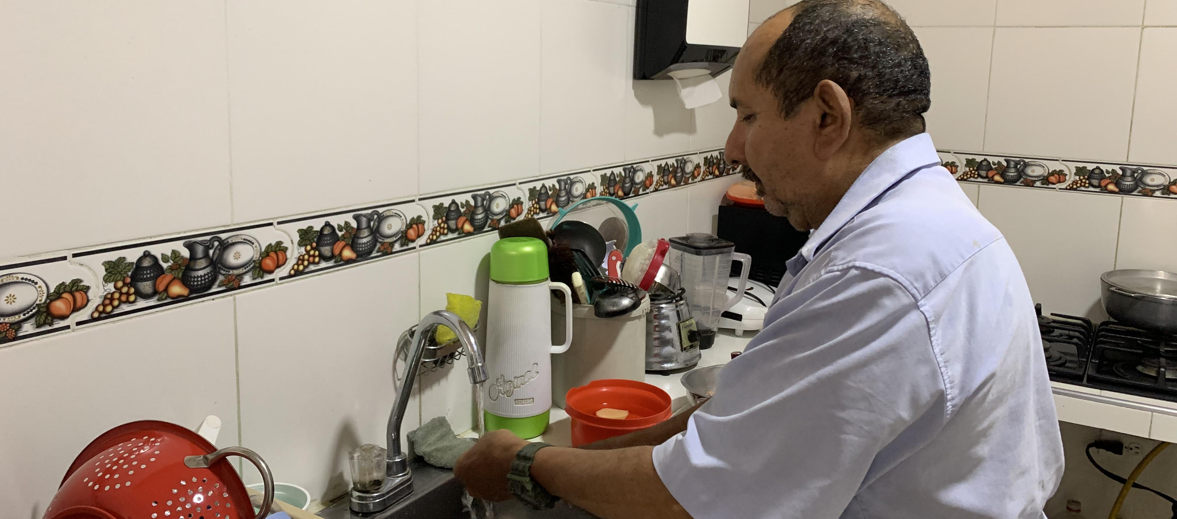 Jorge Madera lavando los platos en su nueva cocina.