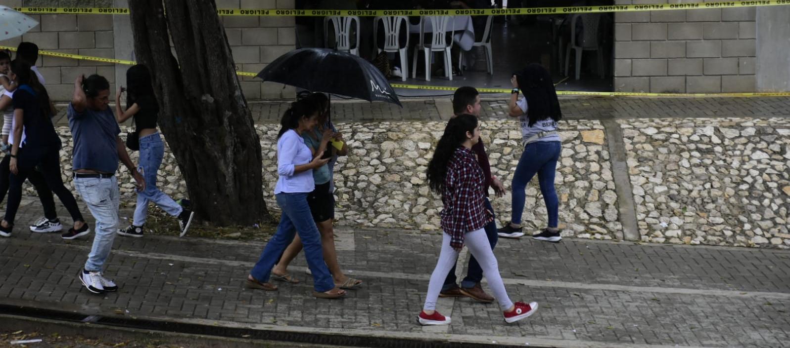 Ciudadanos saliendo de la Normal La Hacienda bajo la lluvia.