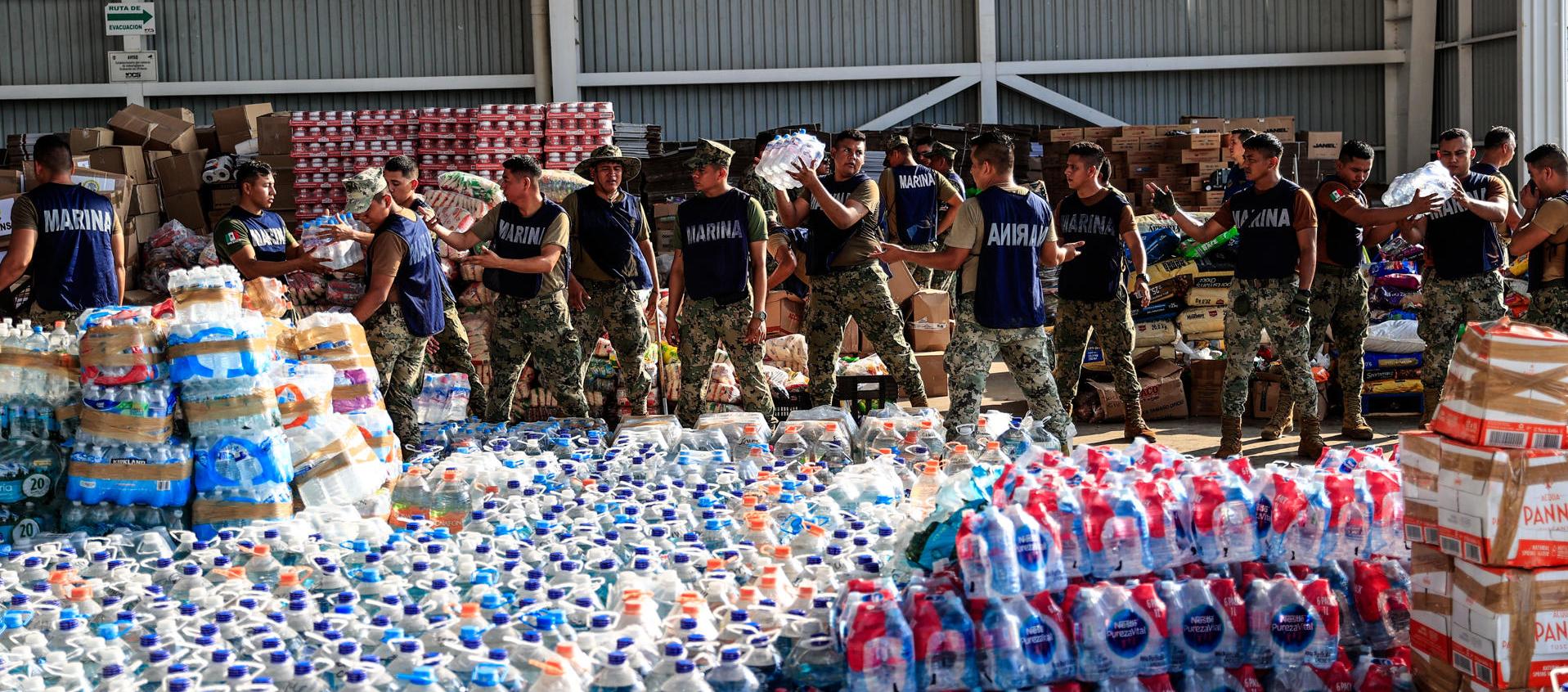 Personal de la Marina empaqueta y traslada despensas a una zona afectada tras el paso del huracán Otis
