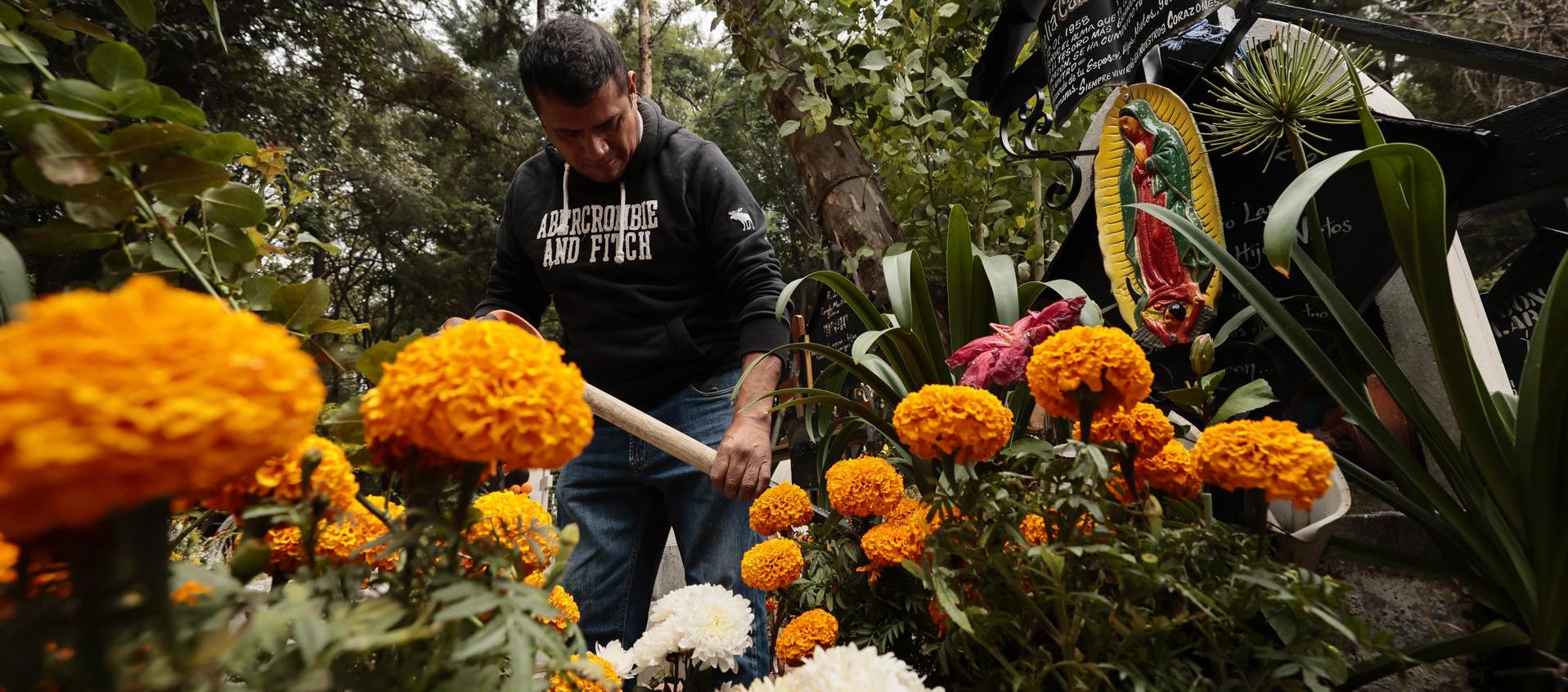 Cientos de personas acuden al Panteón de Xilotepec, en Ciudad de México, para limpiar y adornar las tumbas de sus difuntos y recibirlos en el Día de Muertos. 