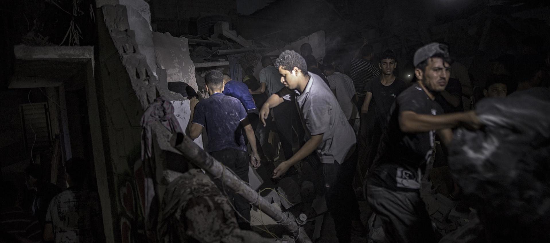 Palestinos buscan cadáveres y supervivientes tras un ataque israelí en Jan Yunis, sur de la Franja de Gaza.