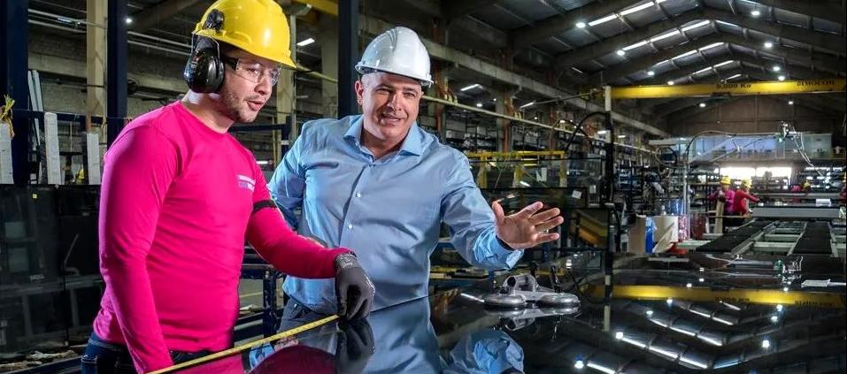 Christian Daes, Director de Operaciones de Tecnoglass, junto a un empleado de una de las plantas