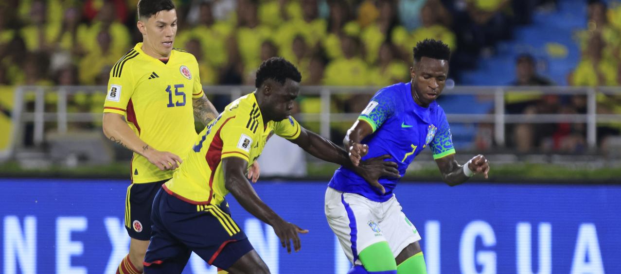 Vinicius Junior intenta zafarse de la marca de Dávinson Sánchez. 