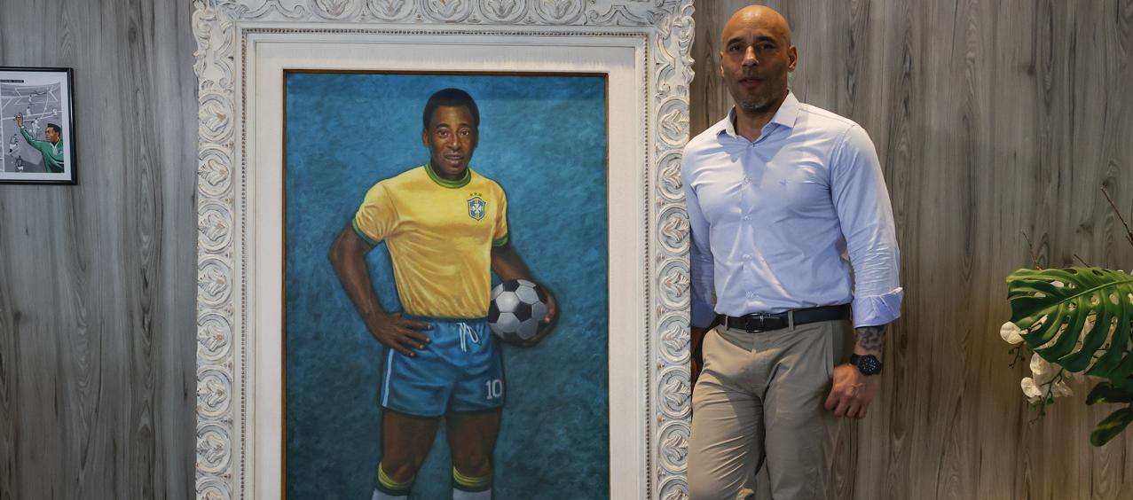 Edinho junto a un retrato de su padre en el Museo Pelé.