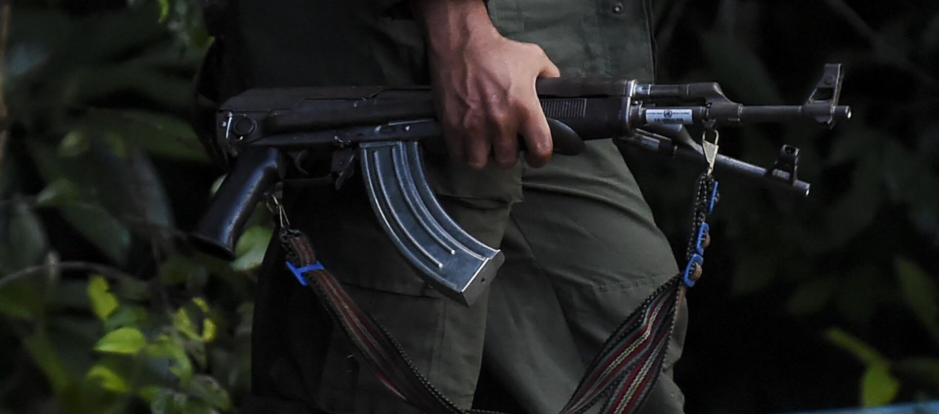 Un hombre de una organización criminal con un fusil en mano.