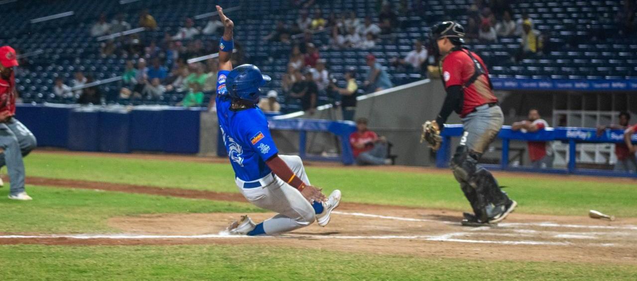 Carlos Arroyo anota la quinta carrera de Caimanes, en el cuarto inning.