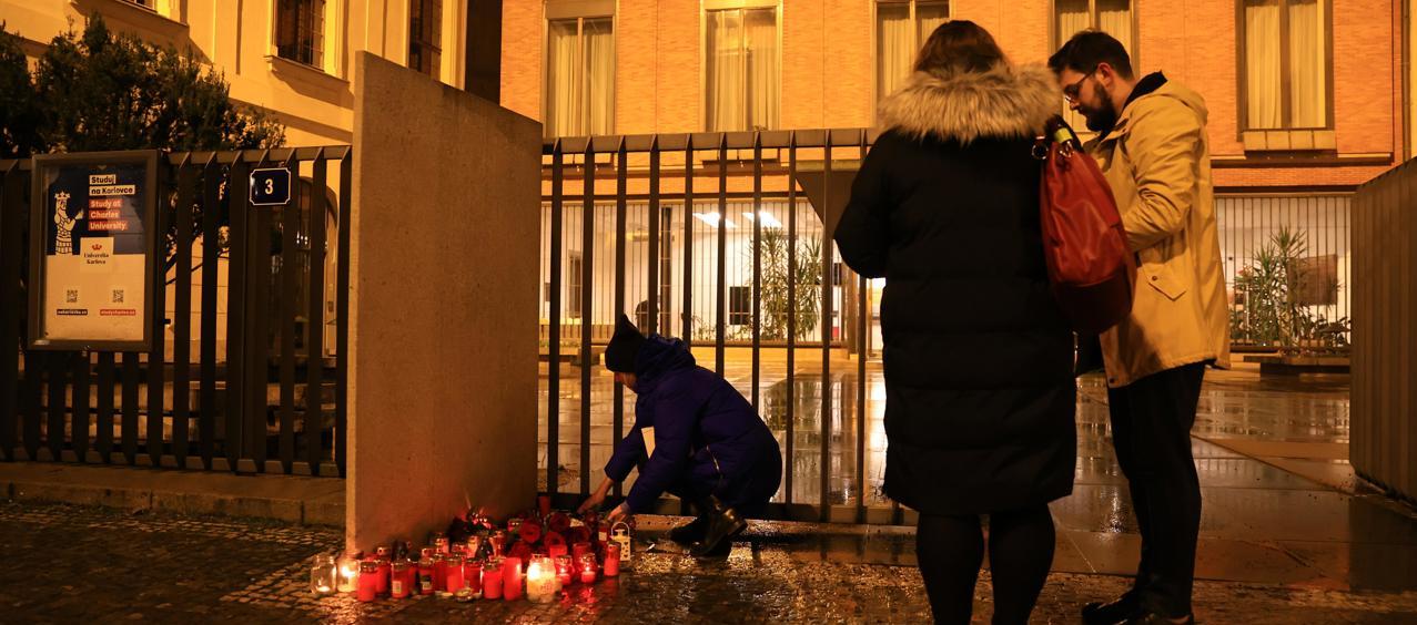 Habitantes de Praga ponen flores ante la fachada de la Universidad Carolina.