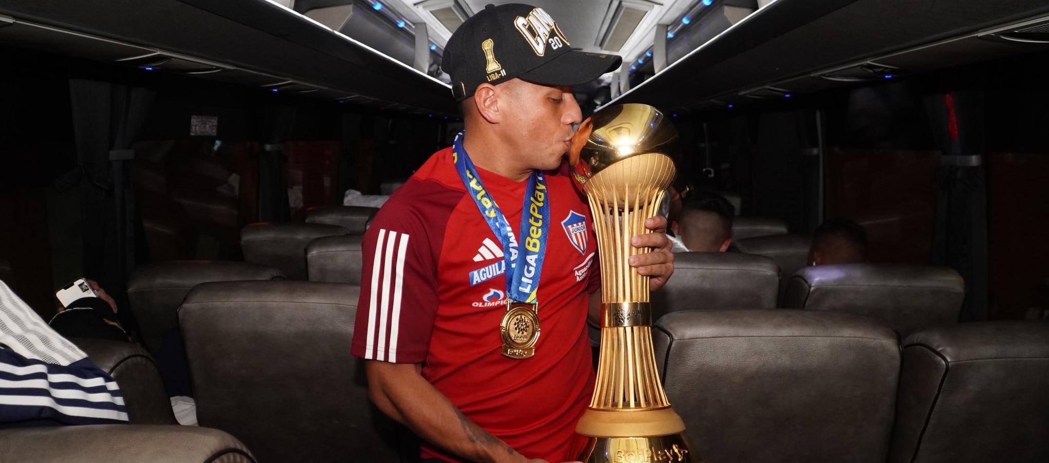 Vladimir Hernández con el trofeo de campeón en el avión que trajo al Junior de regreso a Barranquilla. 